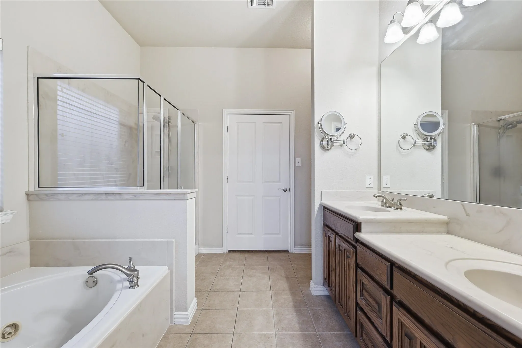 Spacious primary bathroom features dual sinks, a jetted tub, large separate shower, and generous sized walk-in closet.