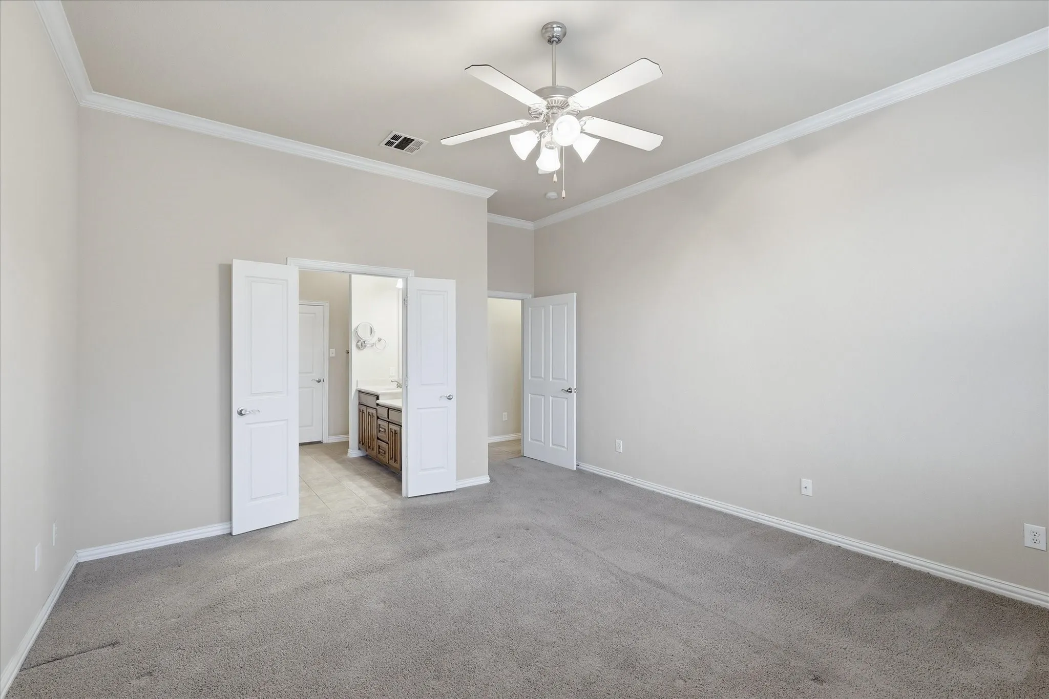 Spacious first floor primary bedroom opens to the ensuite bath and large walk-in closet.