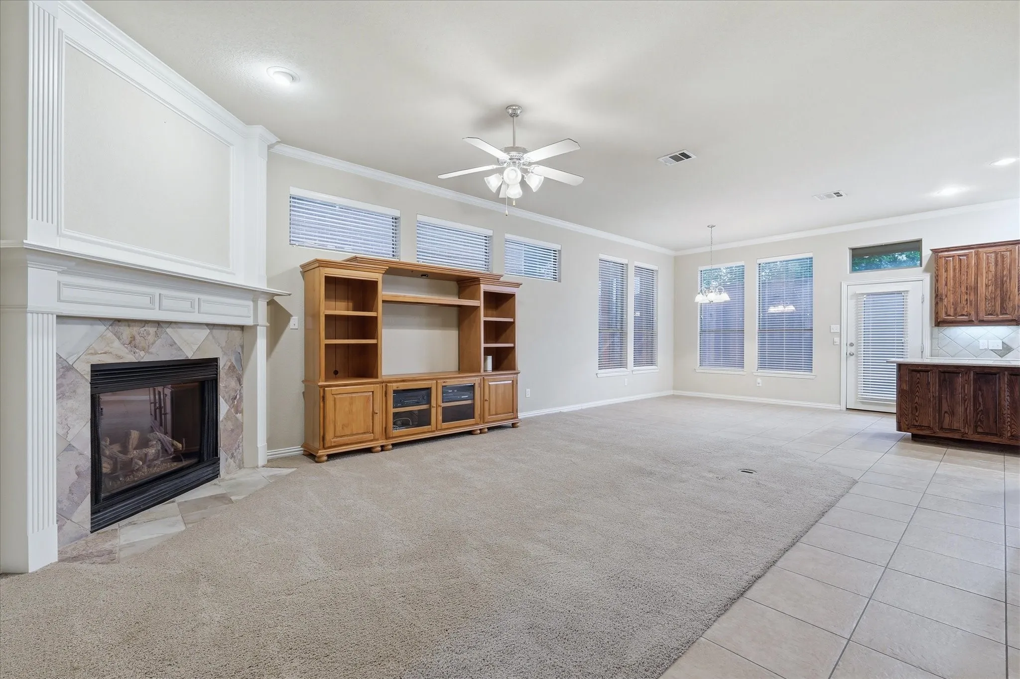 Spacious living area featuring a gas flip switch fireplace. Open floorplan provides connectivity to the kitchen area and ease in entertaining.