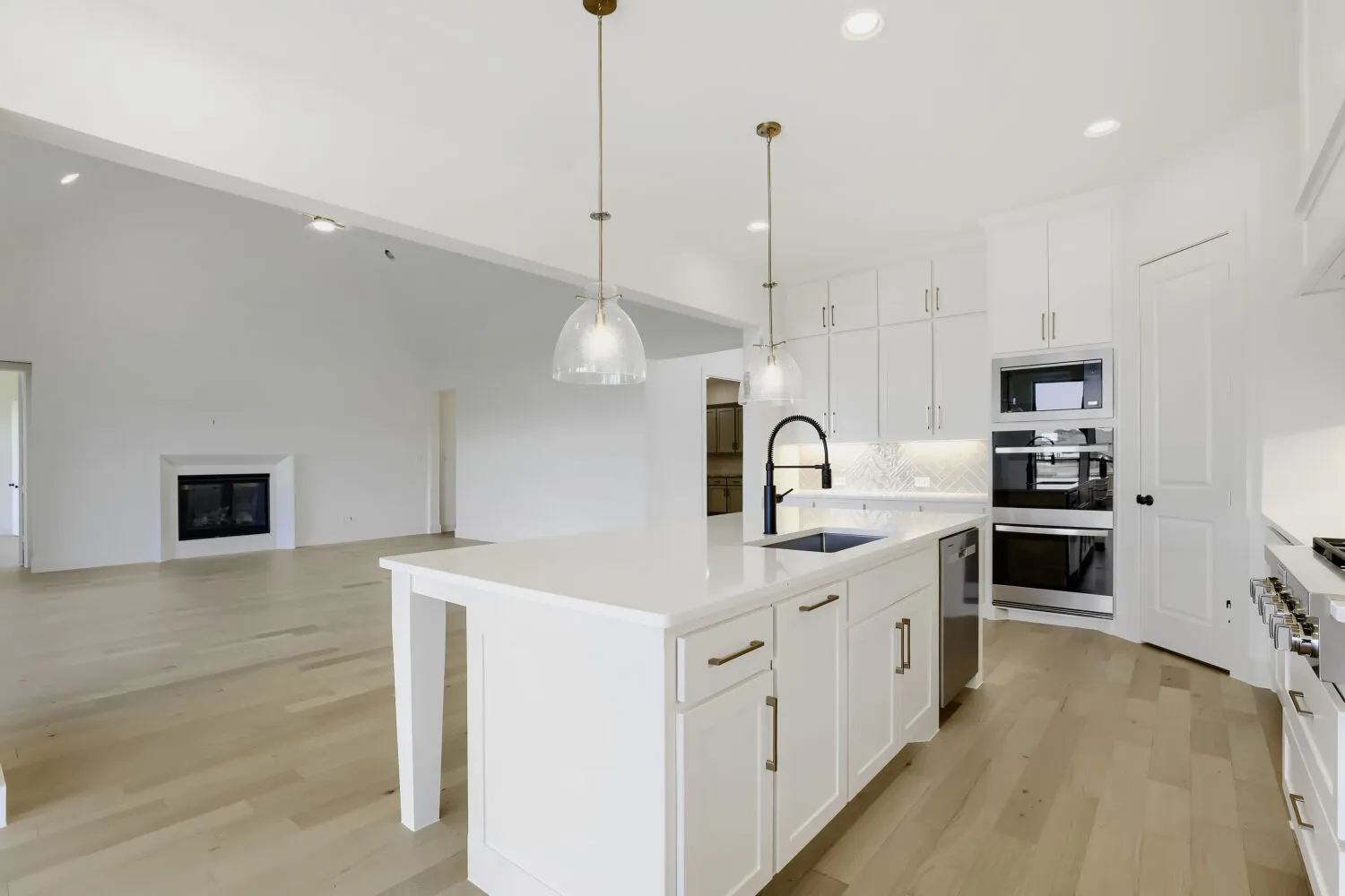 Gourmet kitchen with an expansive island, integrated sink, built-in stainless steel appliances, and ceiling-height cabinetry