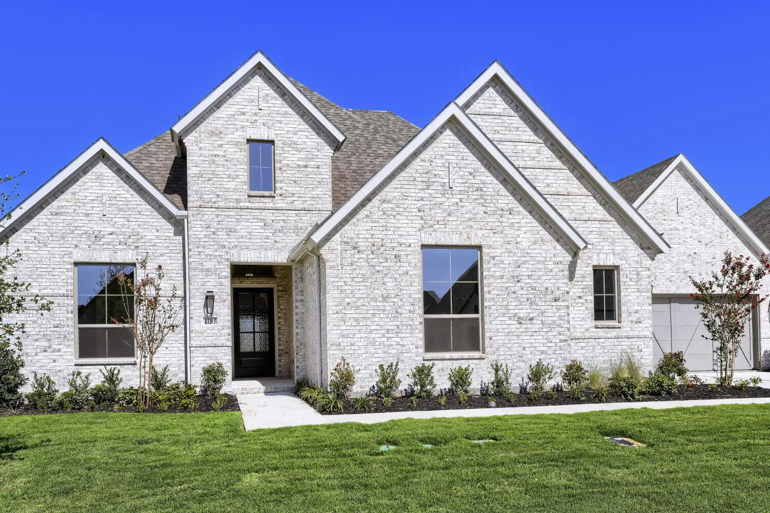 Light-colored brick exterior with multiple gables