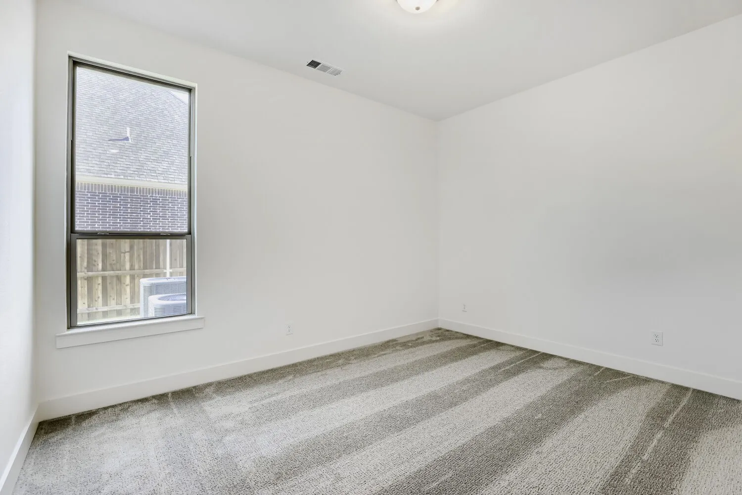 Neutral wall finishes, recessed ceiling light, and patterned carpet