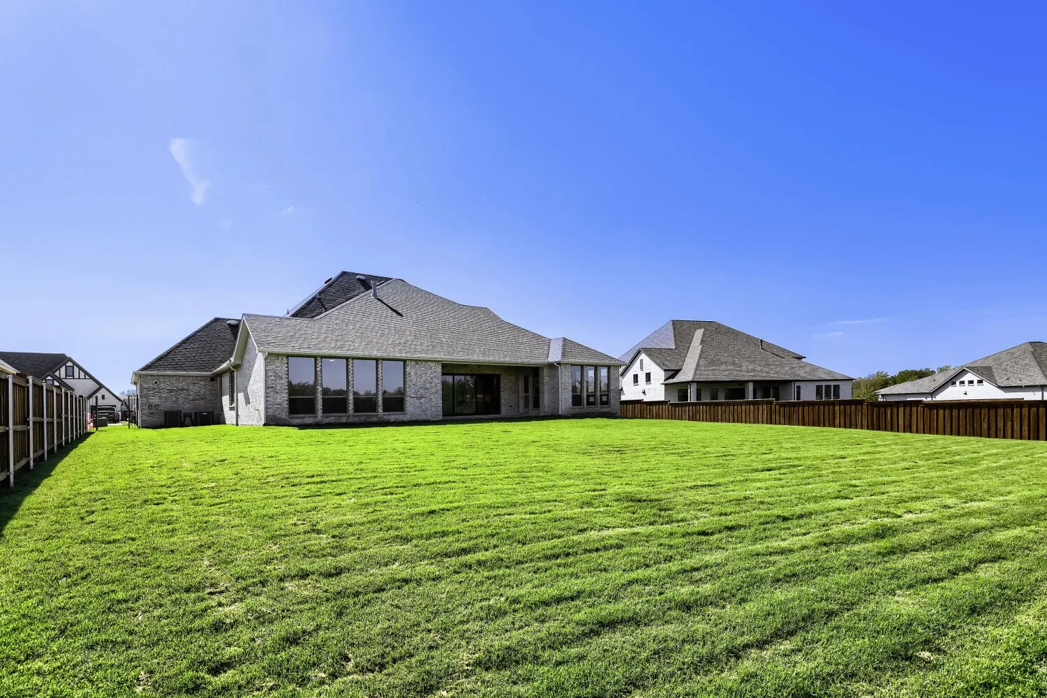 Expansive green lawn with a privacy fence