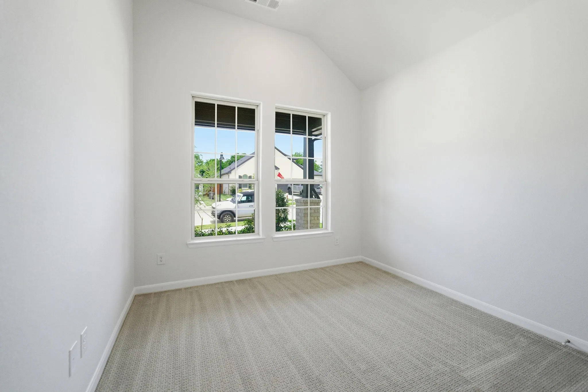 Bright interior space featuring a vaulted ceiling and neutral wall finishes
