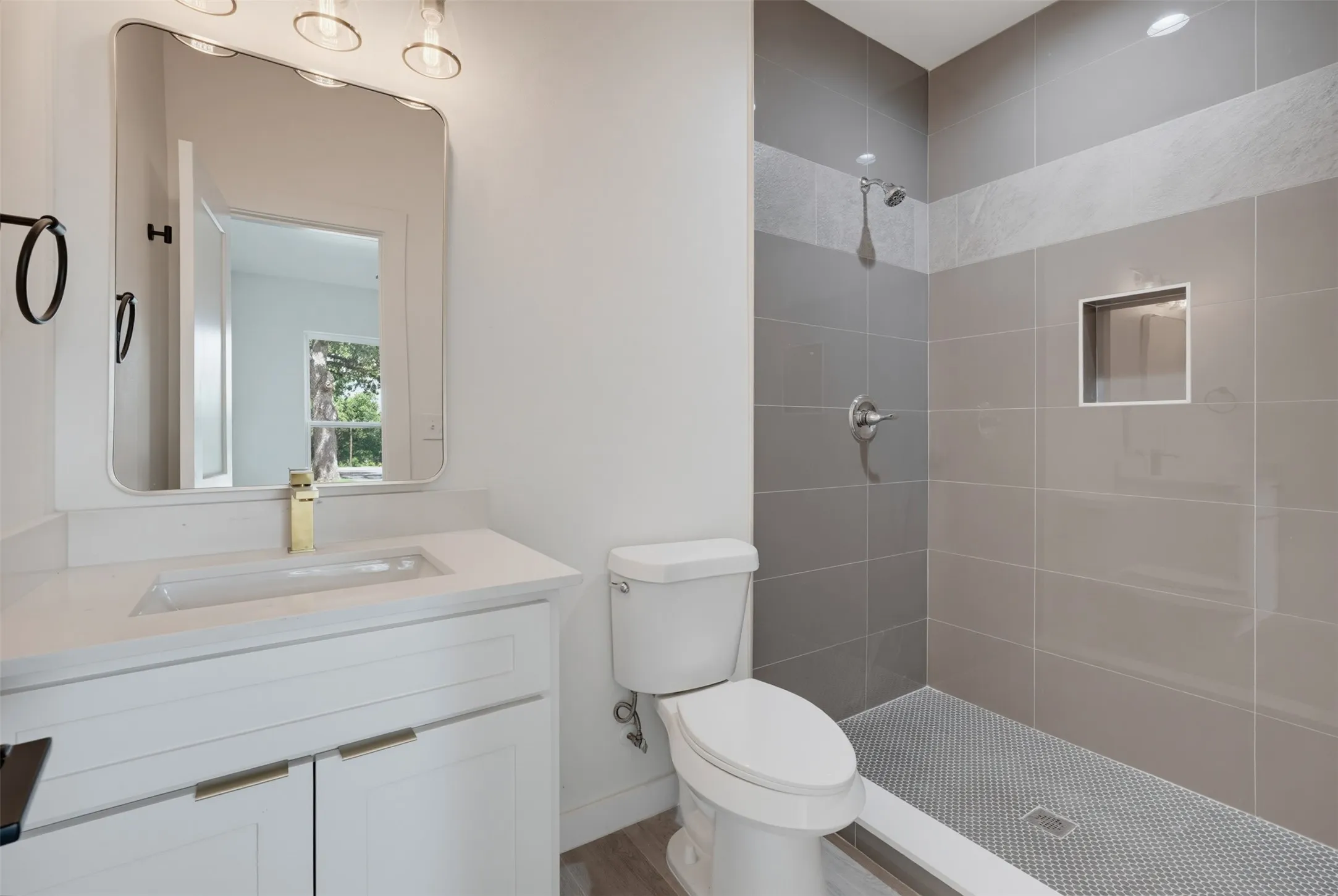 Bathroom featuring a white vanity with gold-finish hardware, a rectangular undermount sink, and a gold-finish faucet