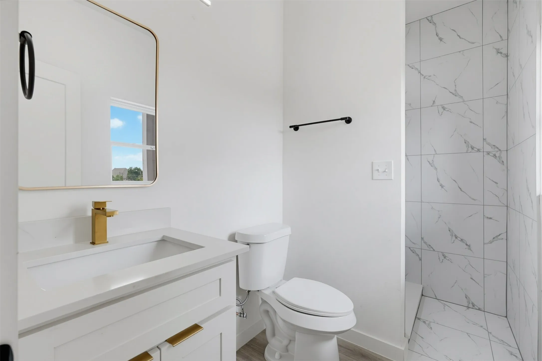 Bathroom vanity featuring a gold-finish faucet and cabinet hardware