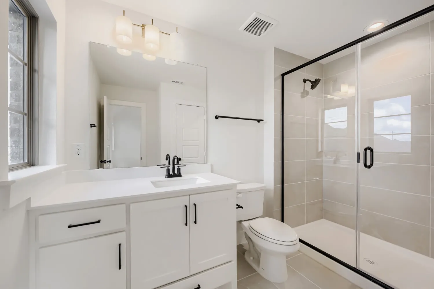 White vanity with a rectangular sink, black-finish faucet, and a large mirror