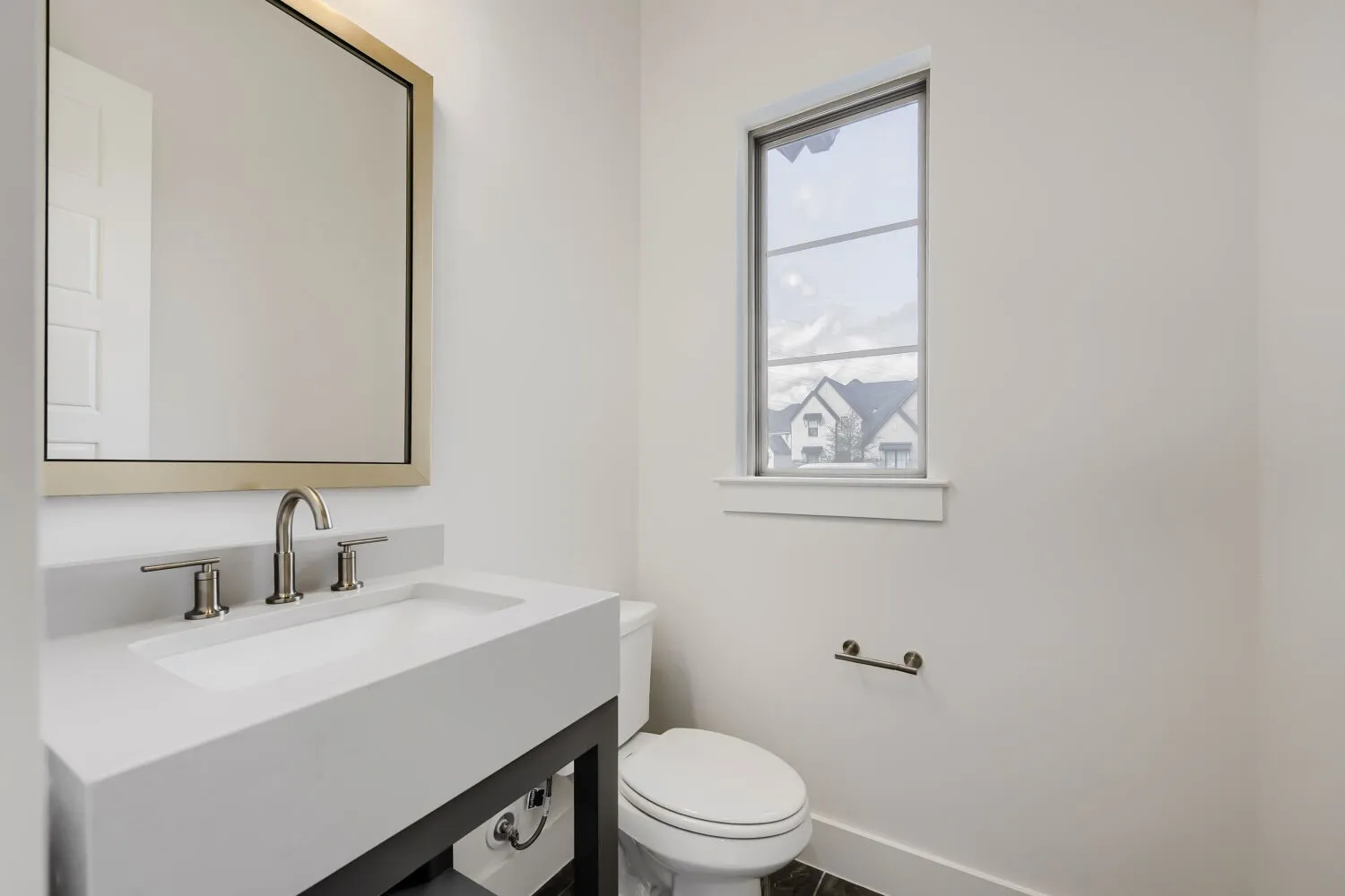 Integrated rectangular sink with brushed nickel faucet, framed mirror, and vertical window