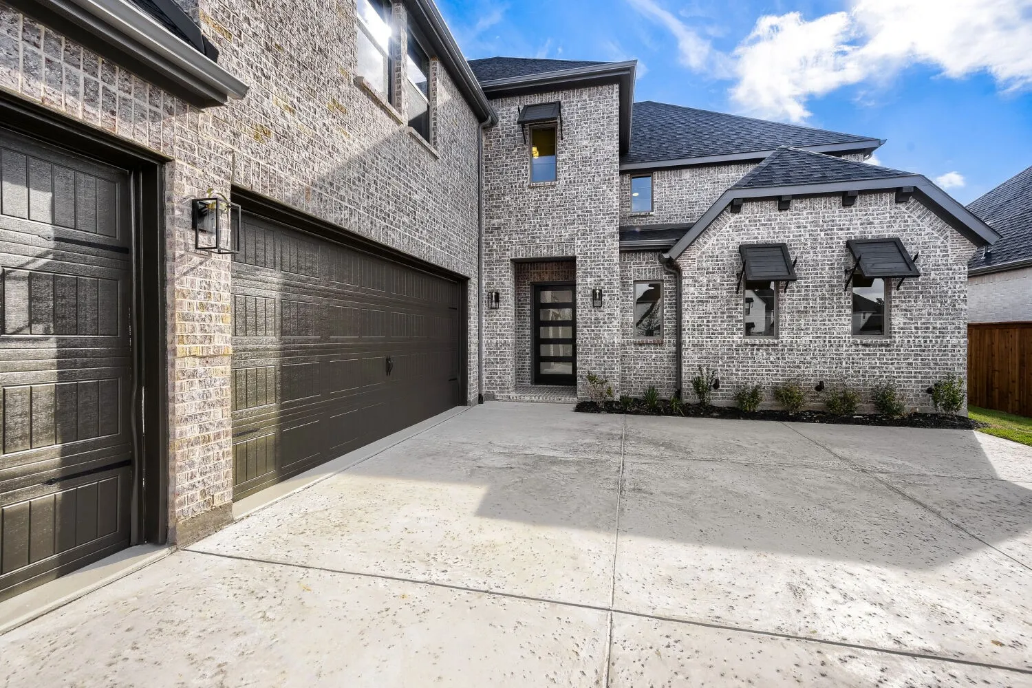 Multi-car garage with dark paneled doors