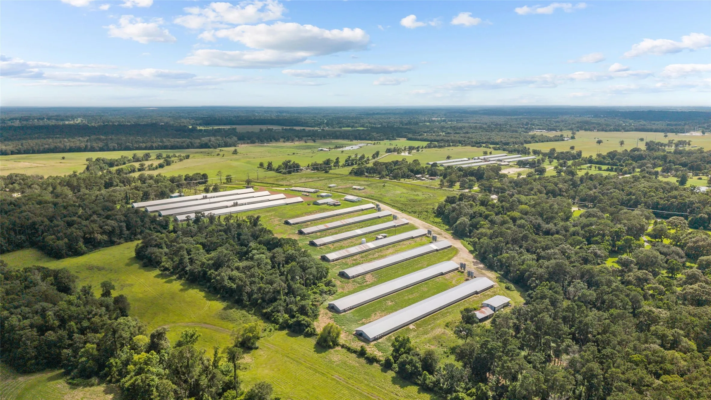 Expansive agricultural property featuring multiple pou, extensive open land, and perimeter fencing