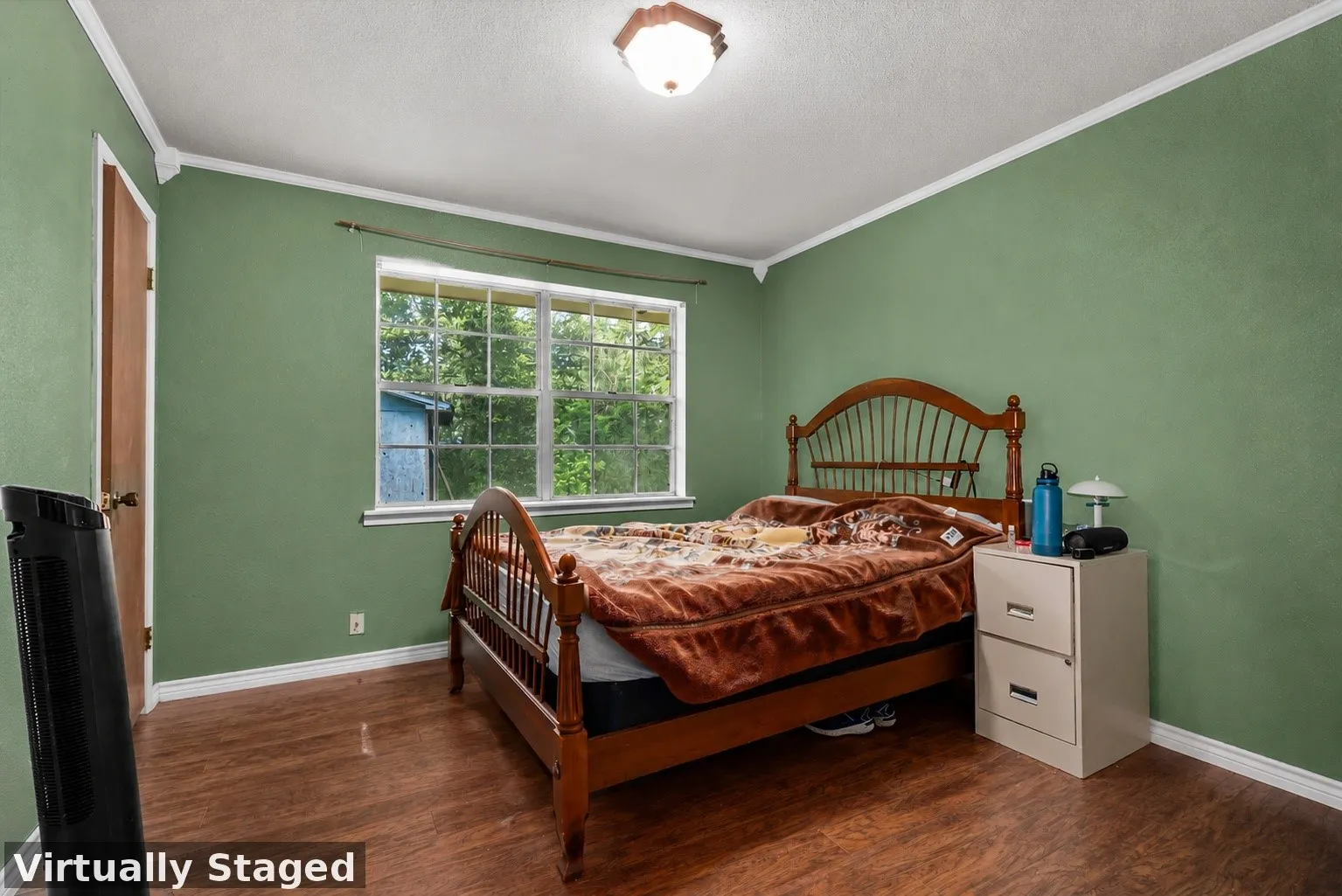 Bedroom featuring wood-finish flooring, a double-paned window, painted walls, and a ceiling-mounted light fixture