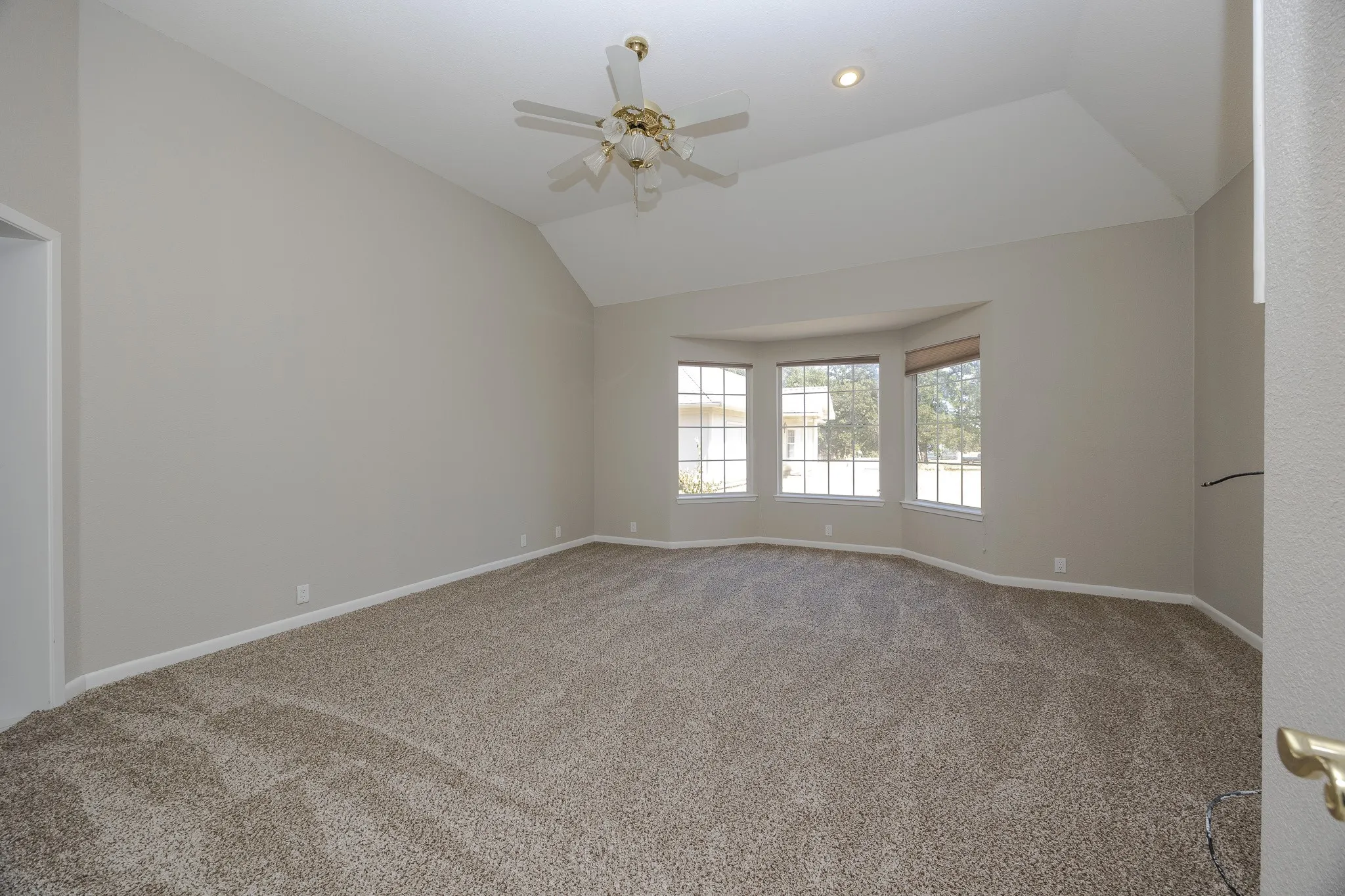Vaulted ceiling with a ceiling fan, bay window with three windows, recessed lighting, and carpet flooring