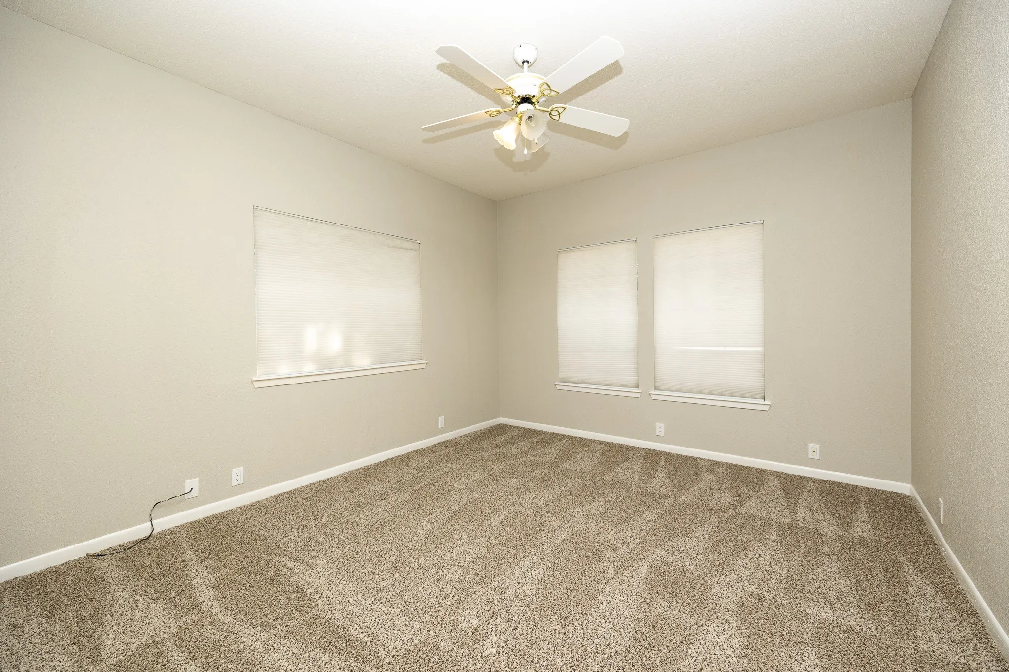 Vaulted ceiling with a ceiling fan, two windows with window treatments, and carpet flooring