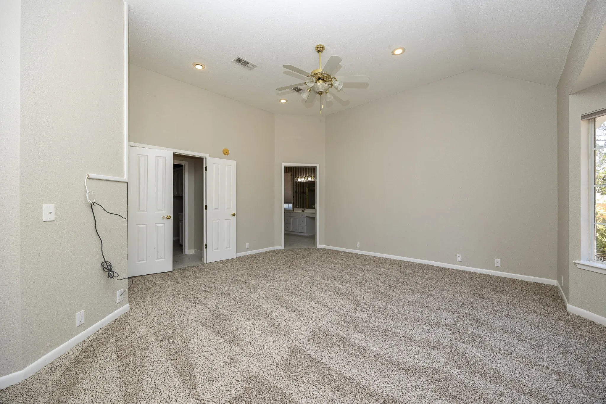 Vaulted ceiling with recessed lighting and a ceiling fan