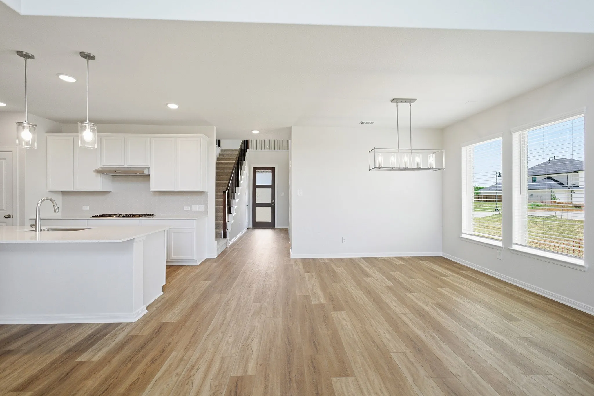Spacious open-concept living area featuring wood-finish flooring