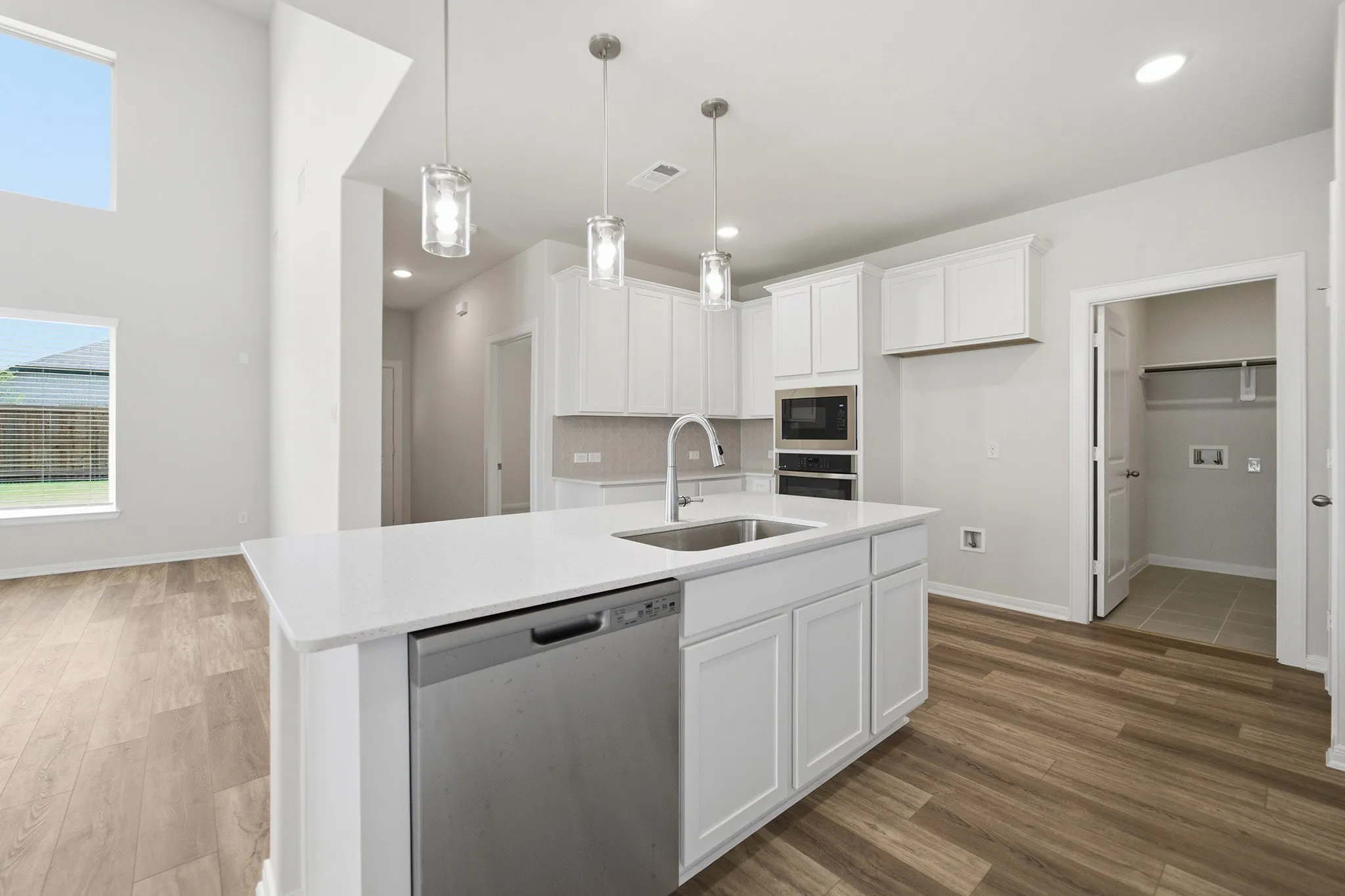 Modern kitchen island with an undermount sink, gooseneck faucet, and integrated stainless steel dishwasher
