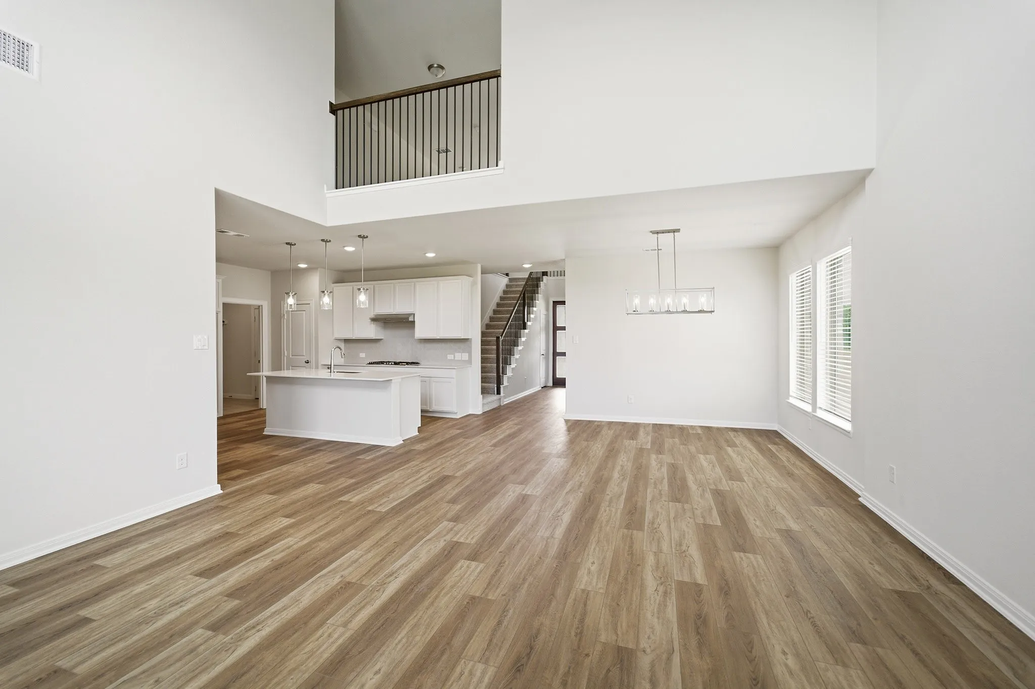 Open-concept living space with high ceilings and wood-finish flooring