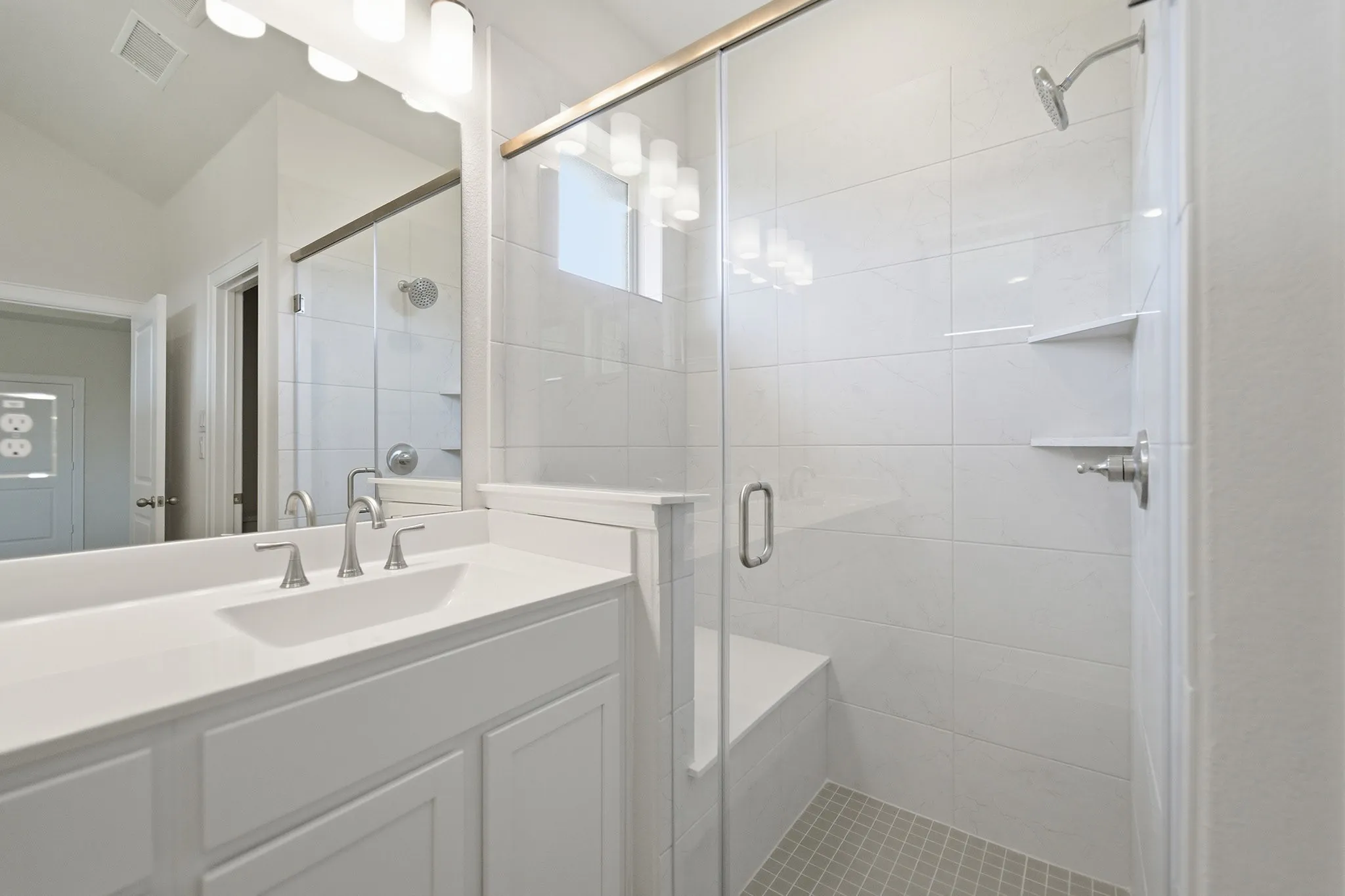 Bathroom featuring a dual-sink vanity with a light-colored countertop and brushed nickel fixtures