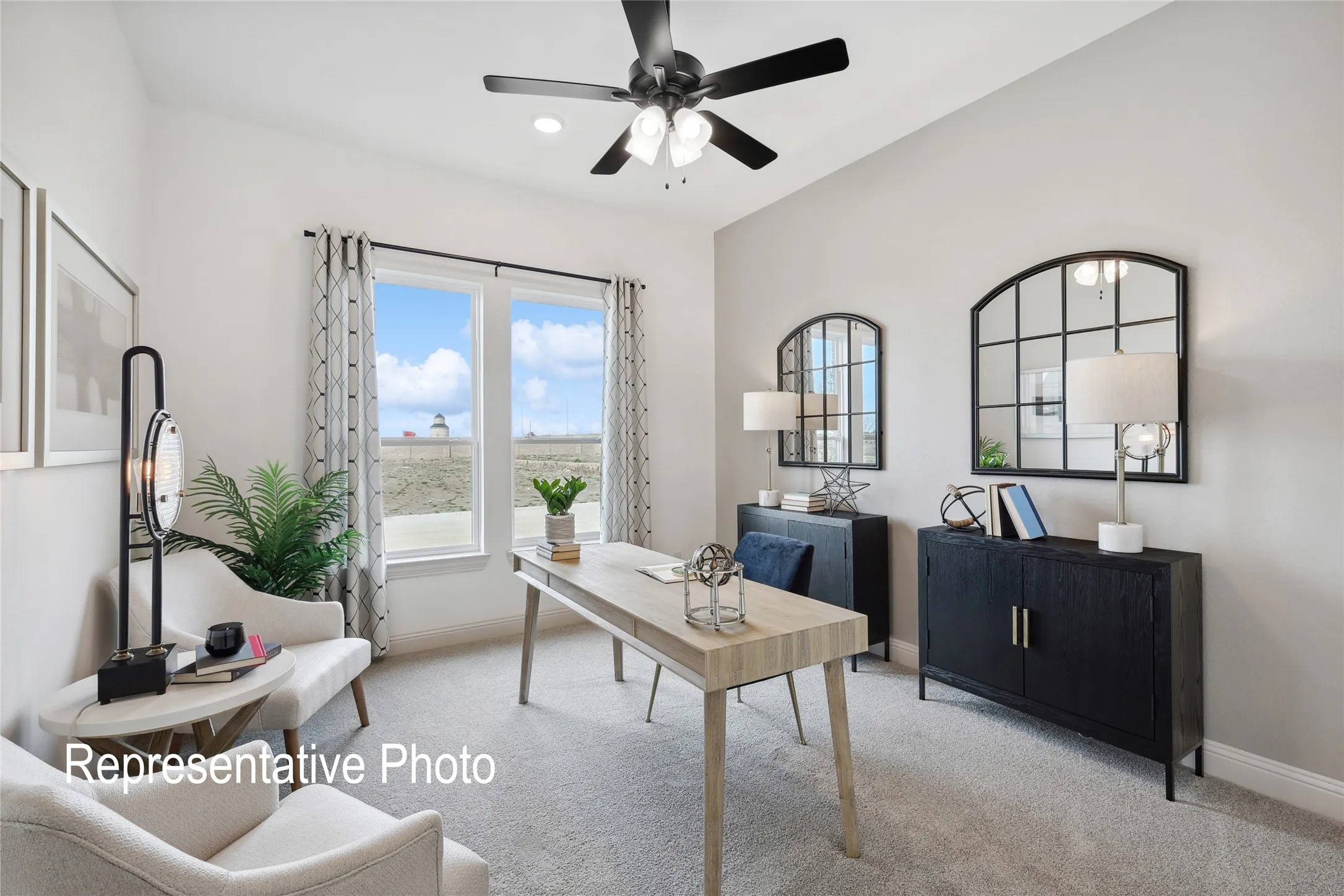 Inviting room featuring a vaulted ceiling with a ceiling fan, dual large windows, and light-toned carpeting