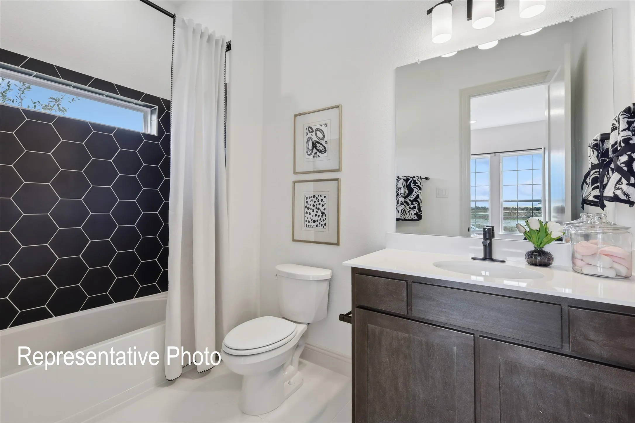 Bathroom featuring a dark wood-finish vanity with a white countertop and undermount sink