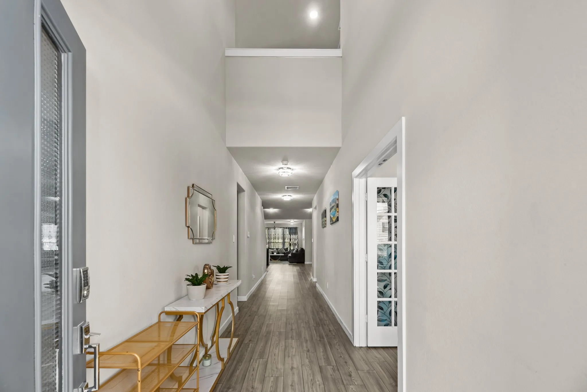 Extended entryway featuring wood-finish flooring, recessed lighting, and a high ceiling