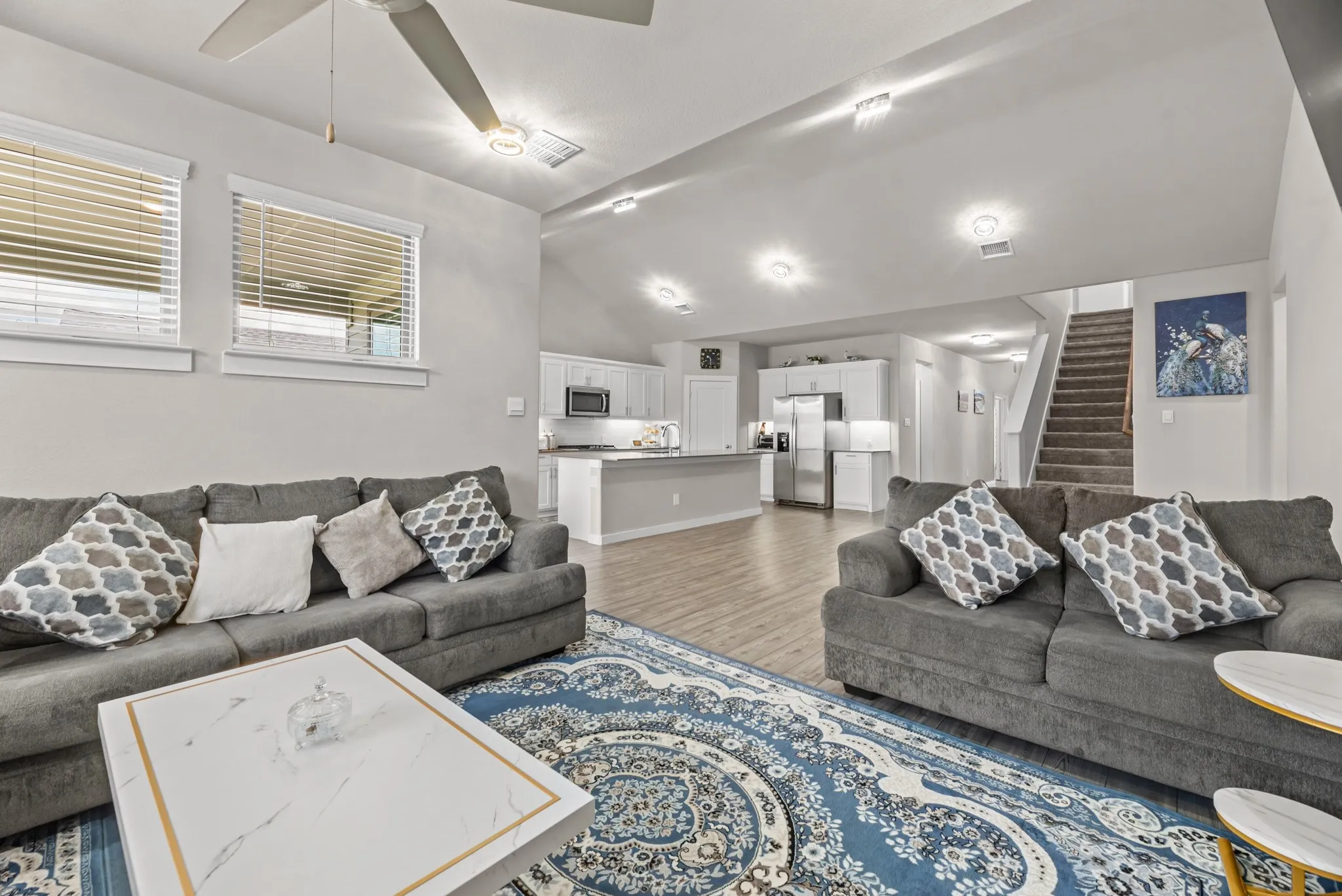 Open-concept living area with wood-finish flooring, recessed lighting, and a ceiling fan