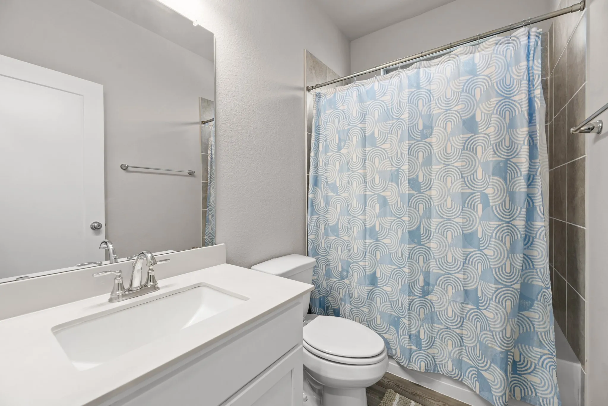 Bathroom featuring a white vanity with an integrated sink, polished chrome faucet, and a large mirror