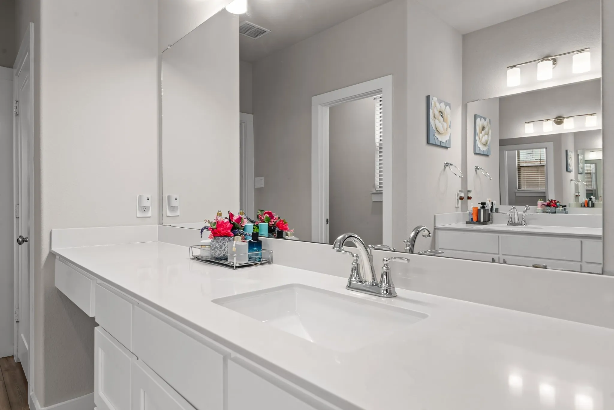 Bathroom vanity featuring a single integrated sink, chrome faucet, and white countertop