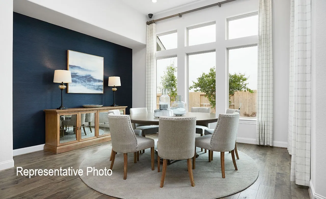 Dining area featuring tall windows, wood-finish flooring, a dark accent wall, and a built-in buffet