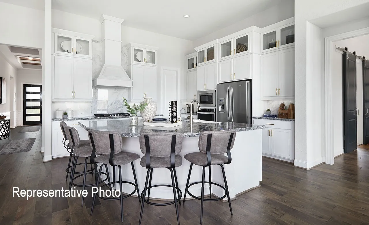Gourmet kitchen featuring a large central island with seating, white shaker cabinetry with glass-front uppers, stainless steel appliances, marble-style backsplash, and wood-finish flooring