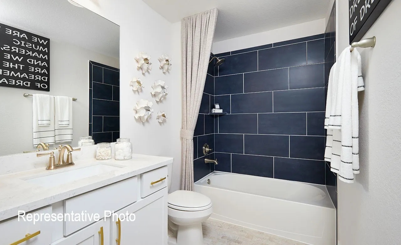 Bathroom featuring a white vanity with gold-finish hardware, integrated sink, and gold-finish faucet