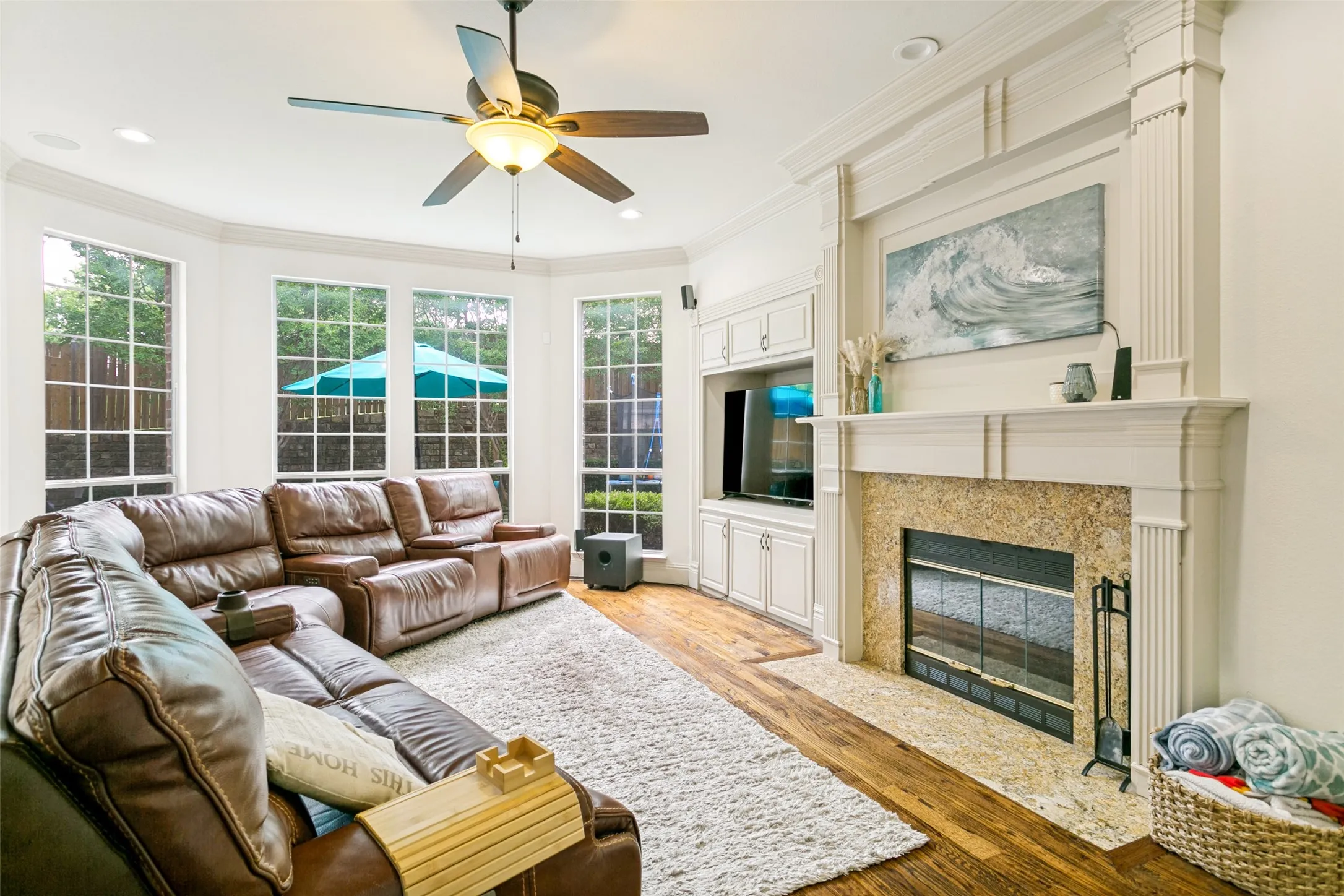 Spacious living area featuring a prominent white mantel fireplace with a granite-style surround and hearth