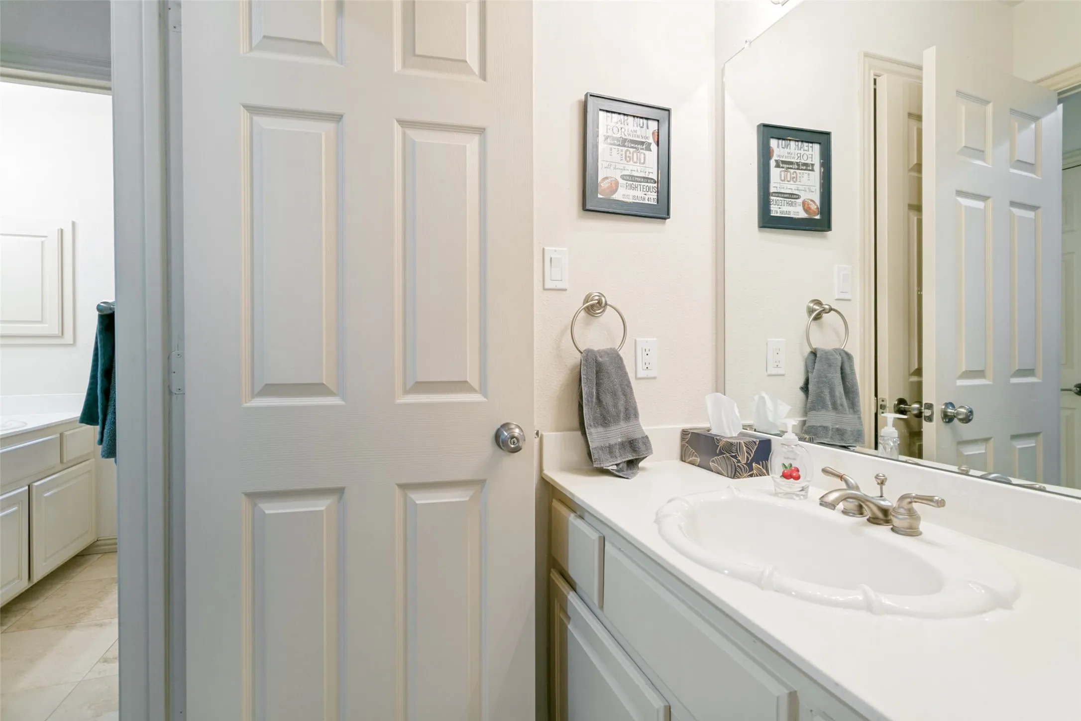 Vanity with a white countertop and an integrated white oval sink featuring a brushed nickel faucet