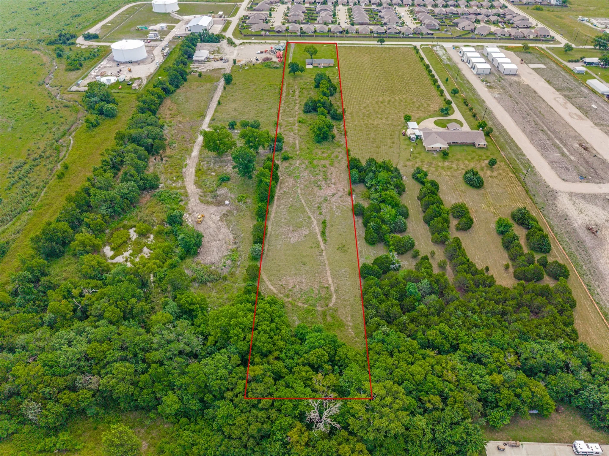 Expansive land parcel featuring a mix of open grassy areas and mature tree coverage