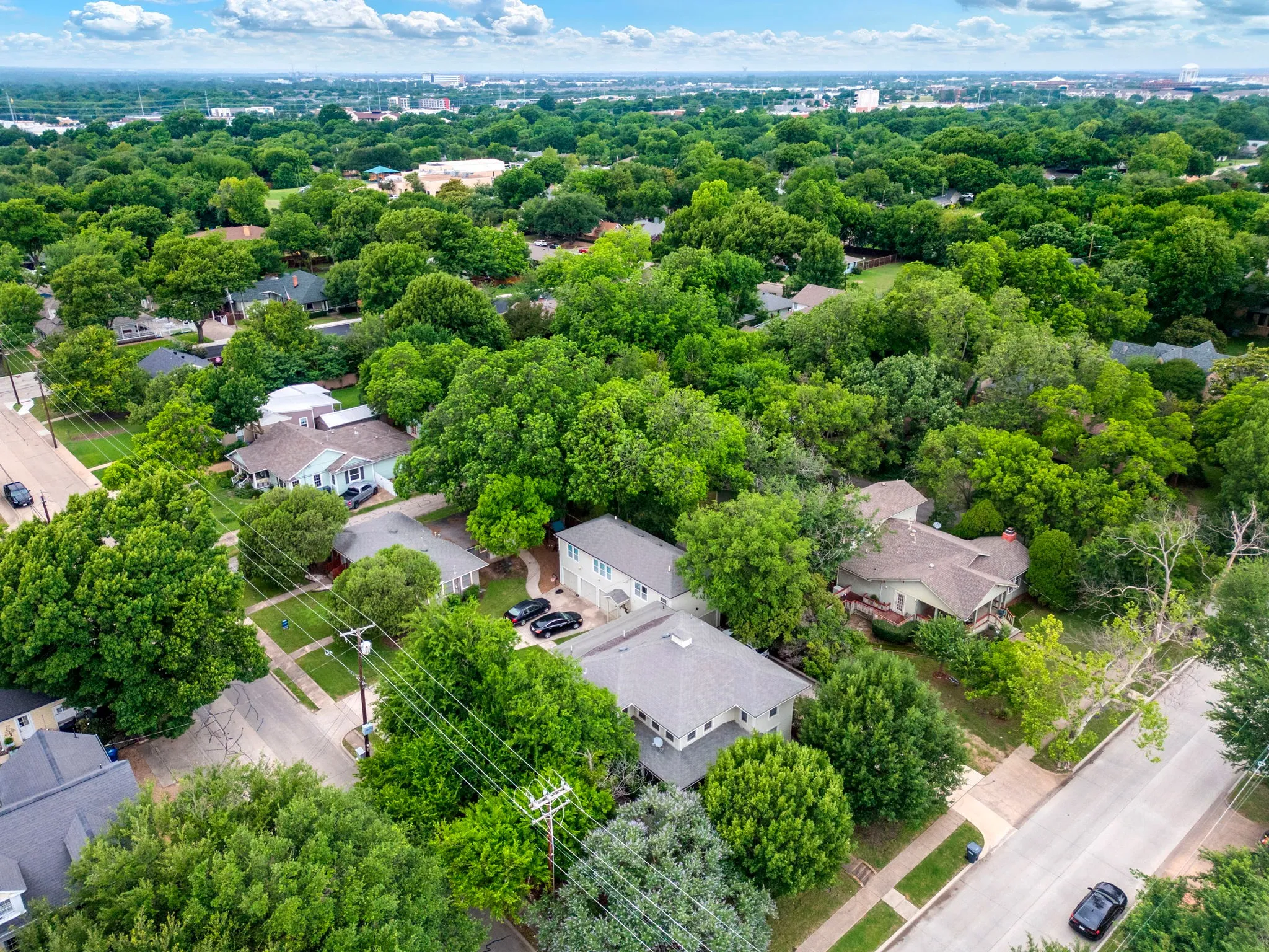 Aerial perspective showcasing a residential area with mature tree canopies
