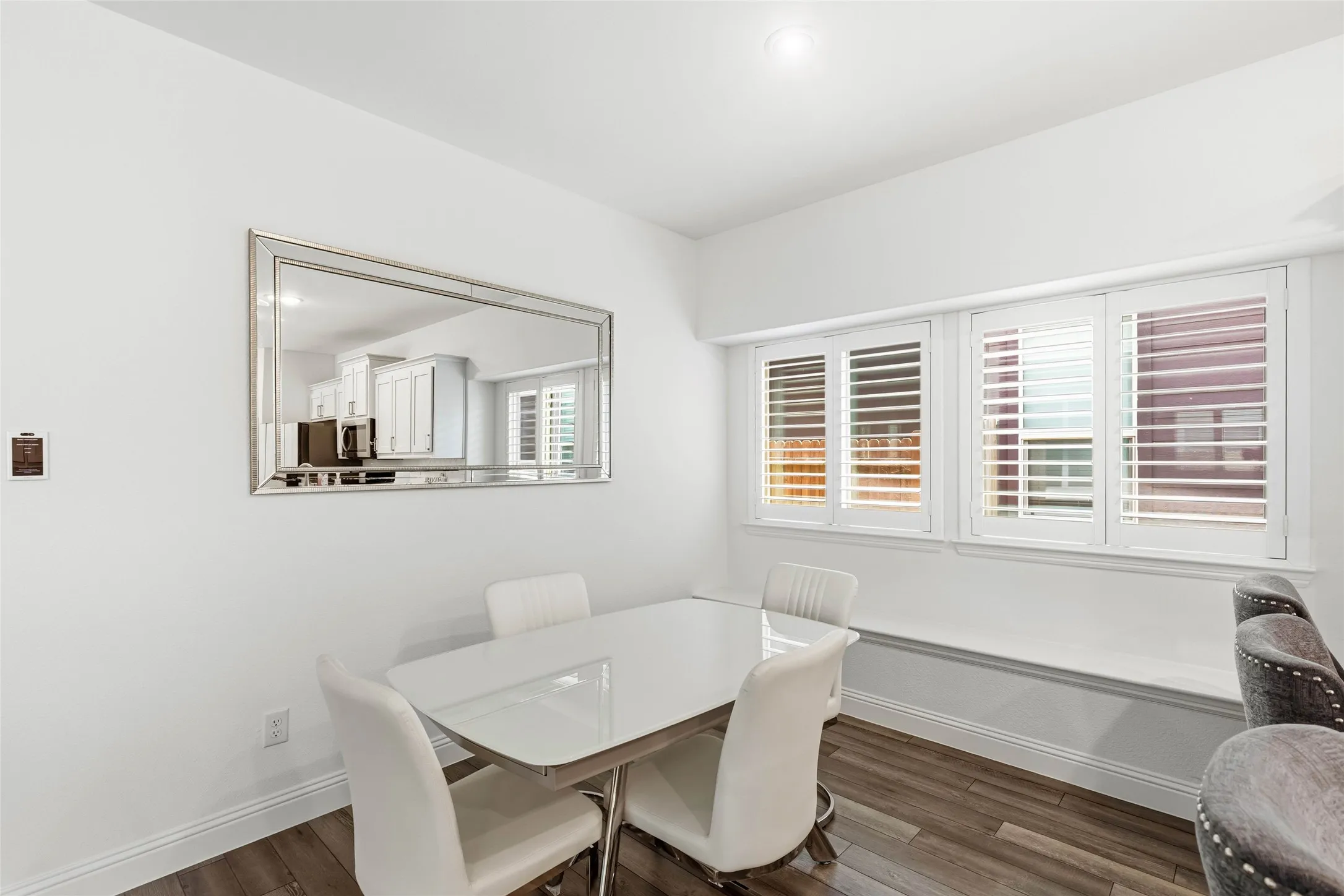 Dining area featuring wood-finish flooring, white walls, and a built-in window bench