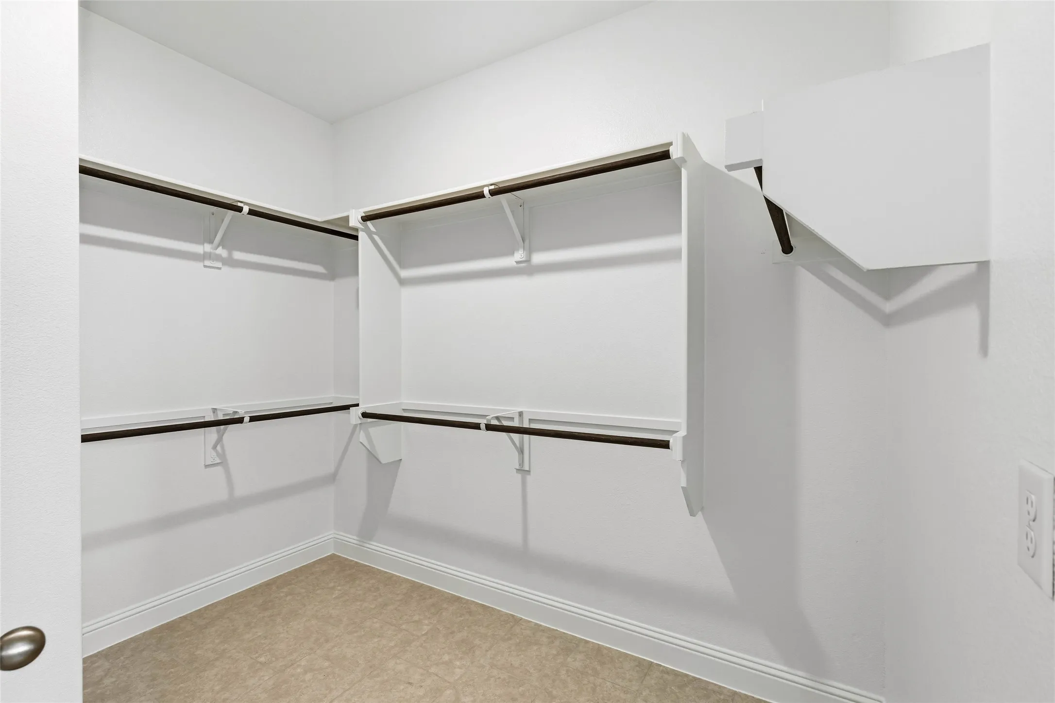 White painted walk-in closet with integrated shelving and hanging rods