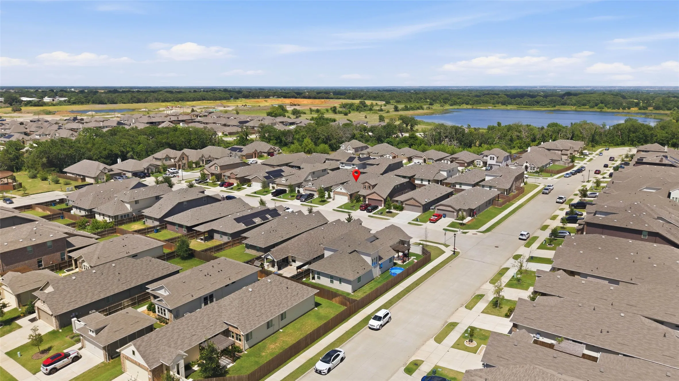 Aerial perspective of a residential community featuring numerous single-family homes with uniform rooflines