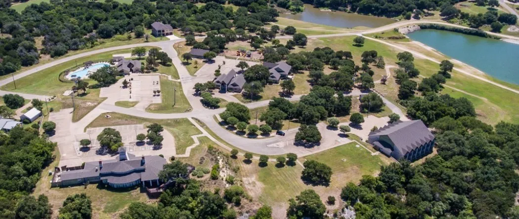 Extensive development featuring multiple structures, paved roadways, surface parking areas, a swimming pool, and two bodies of water