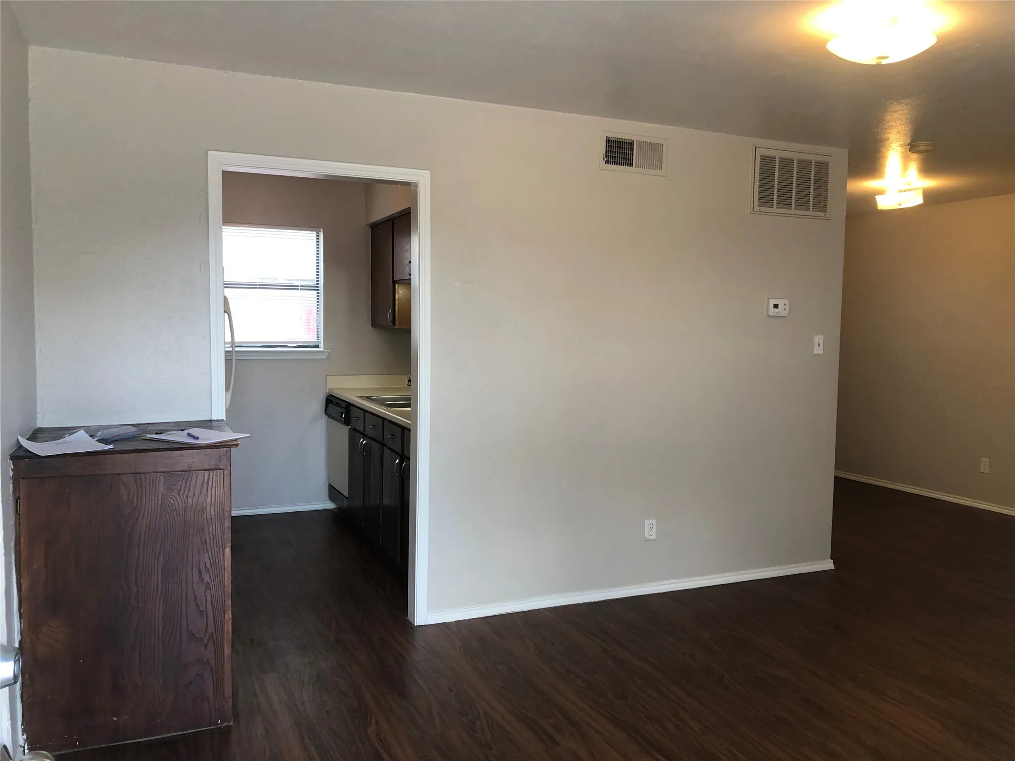 Step into a modern and inviting living space featuring gorgeous dark wood-look flooring and a highly functional open layout. The seamless flow directly into the kitchen makes this the perfect spot for relaxing or entertaining friends.
