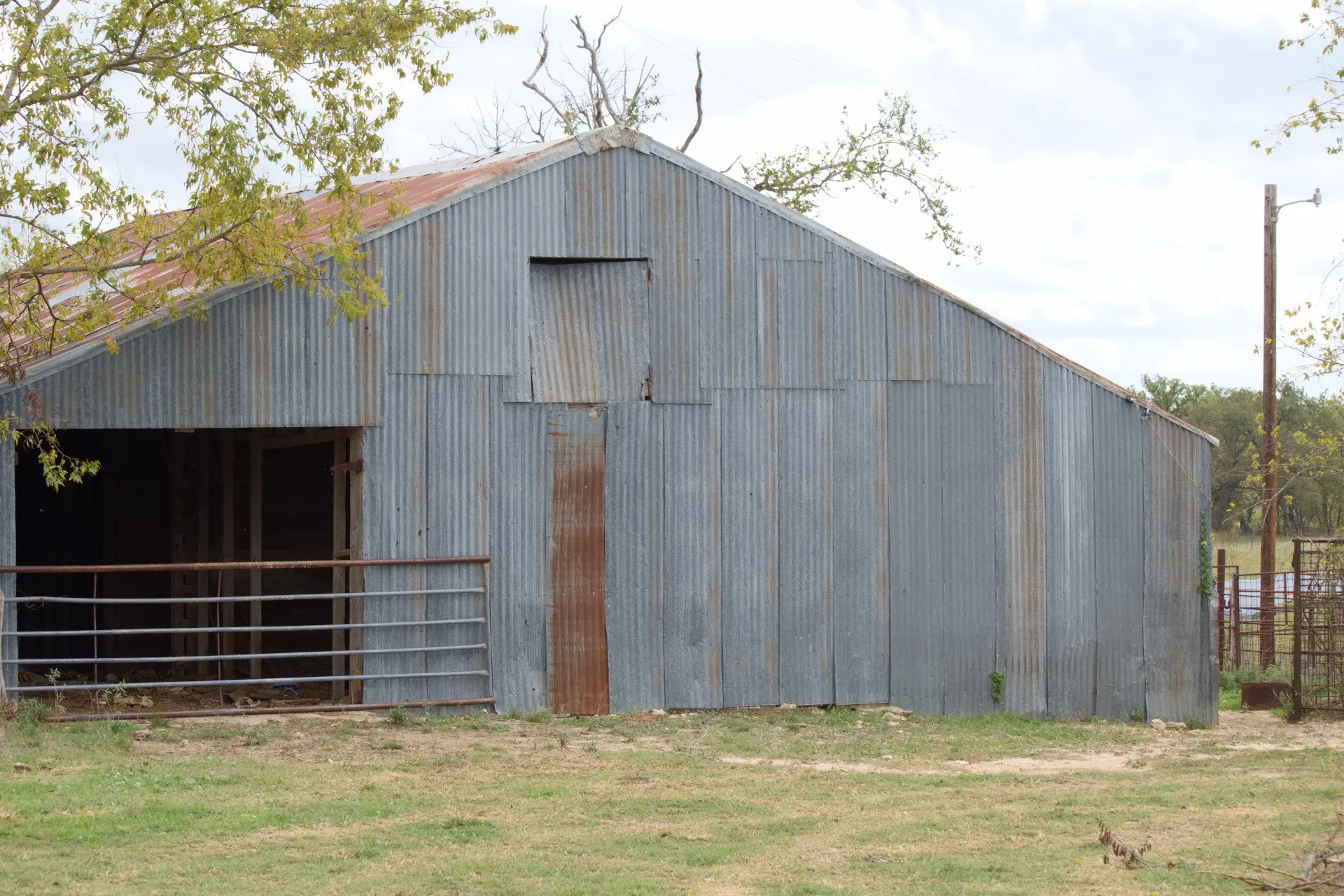 Corrugated metal barn with a pitched roof and a large open bay entrance