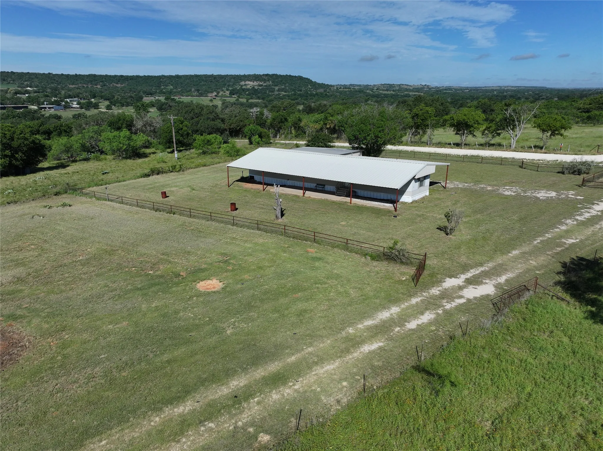 Expansive property featuring a metal-roofed single wide with an extended covered porch