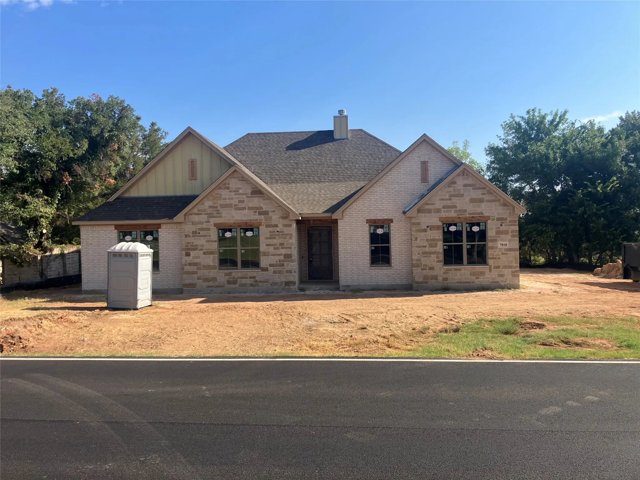 Stone and brick exterior with wood-finish window headers and siding accents