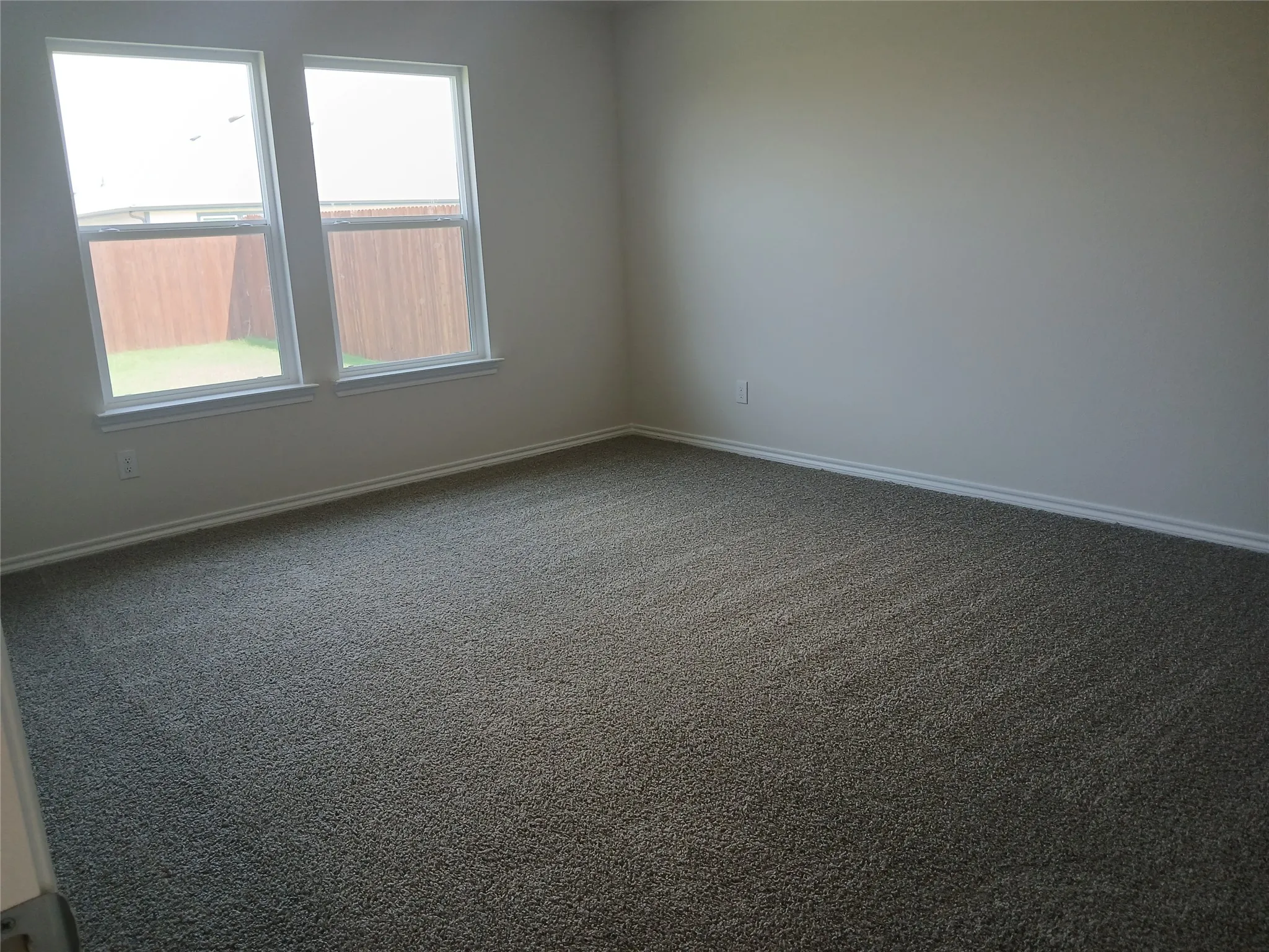 Neutral tone wall finishes, white baseboards, and plush carpet flooring