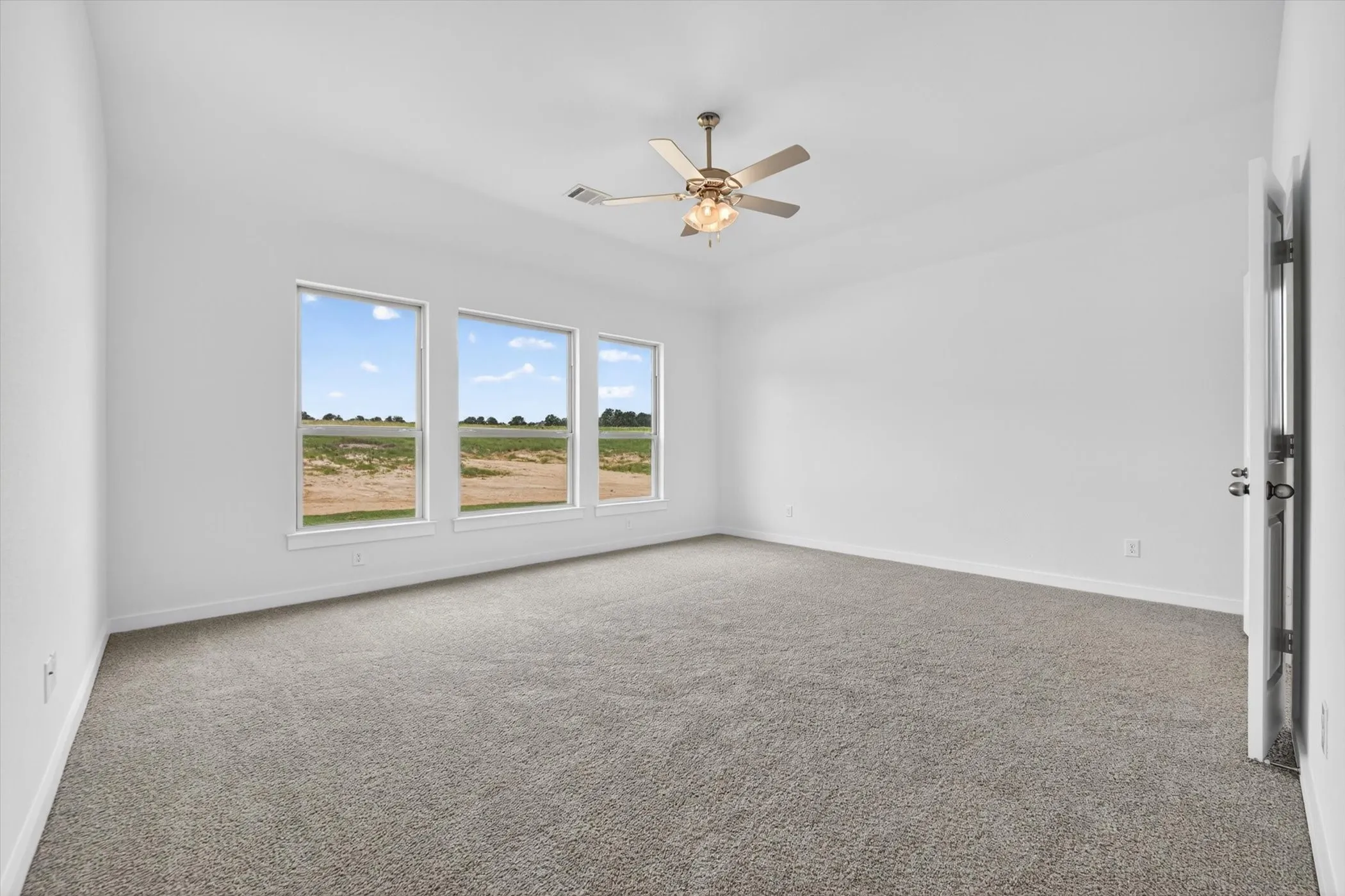 Spacious room featuring vaulted ceilings and light gray carpeting