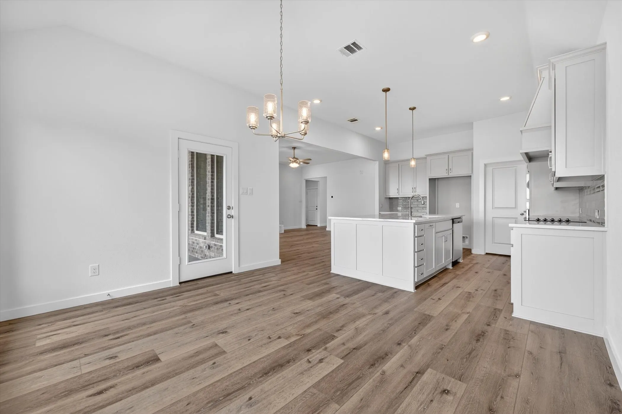 Dining area with wood-finish flooring, a contemporary chandelier, and a built-in​​‌​​​​‌​​‌‌​‌‌​​​‌‌​‌​‌​‌​​​‌​​ sideboard
