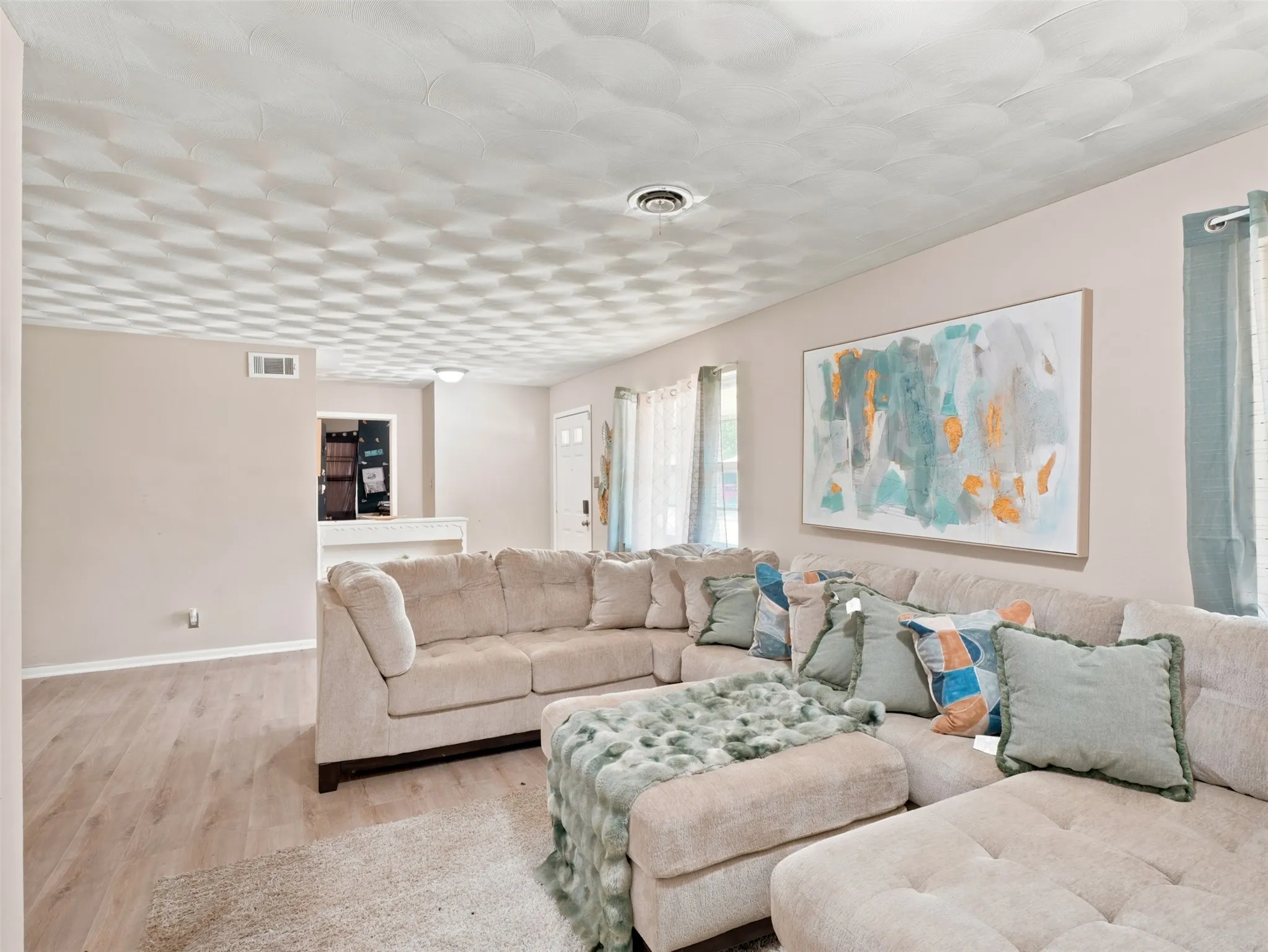 Spacious living area featuring light wood-finish flooring and neutral wall tones