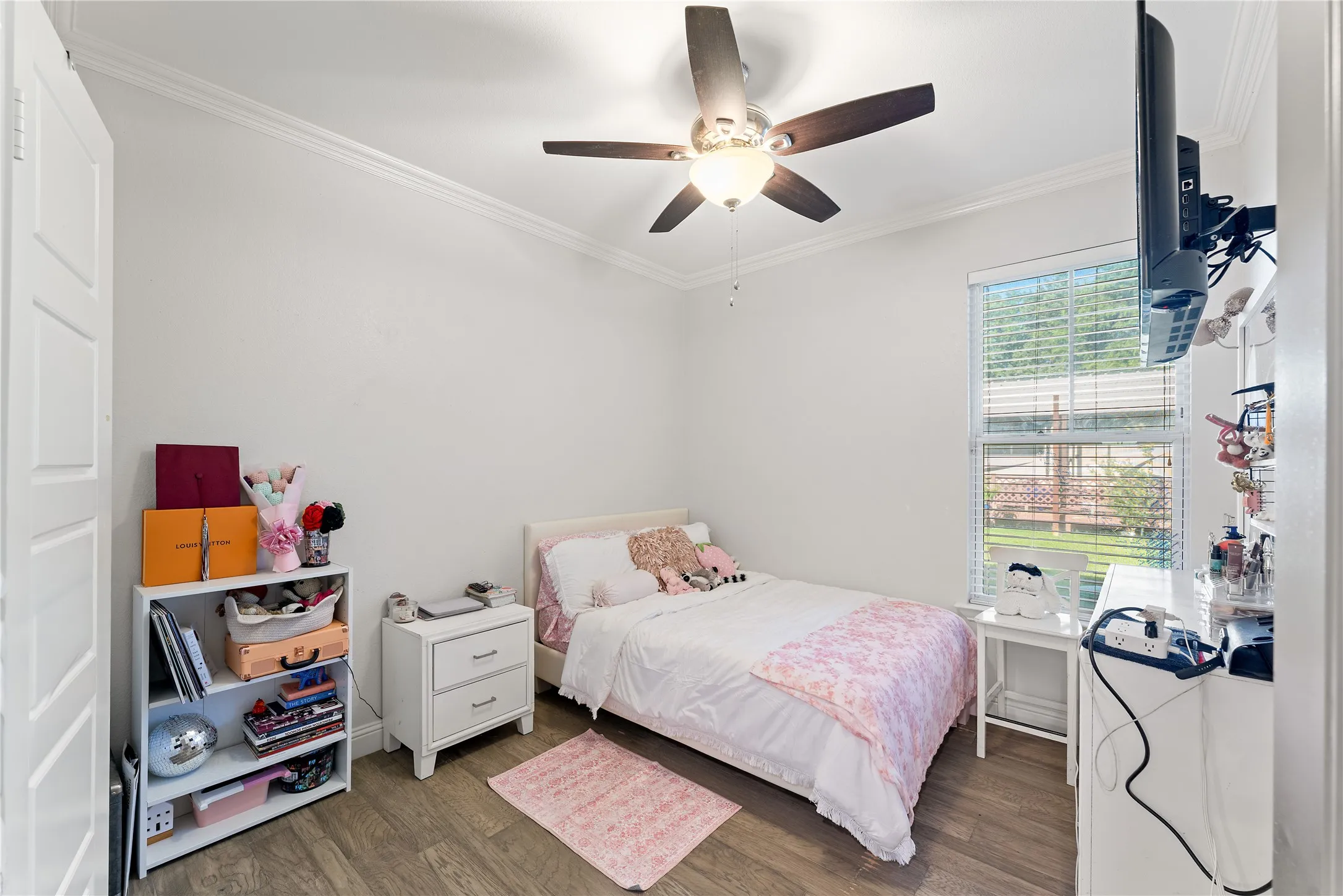 1st Room featuring wood-finish flooring, a ceiling fan with integrated lighting, and crown molding