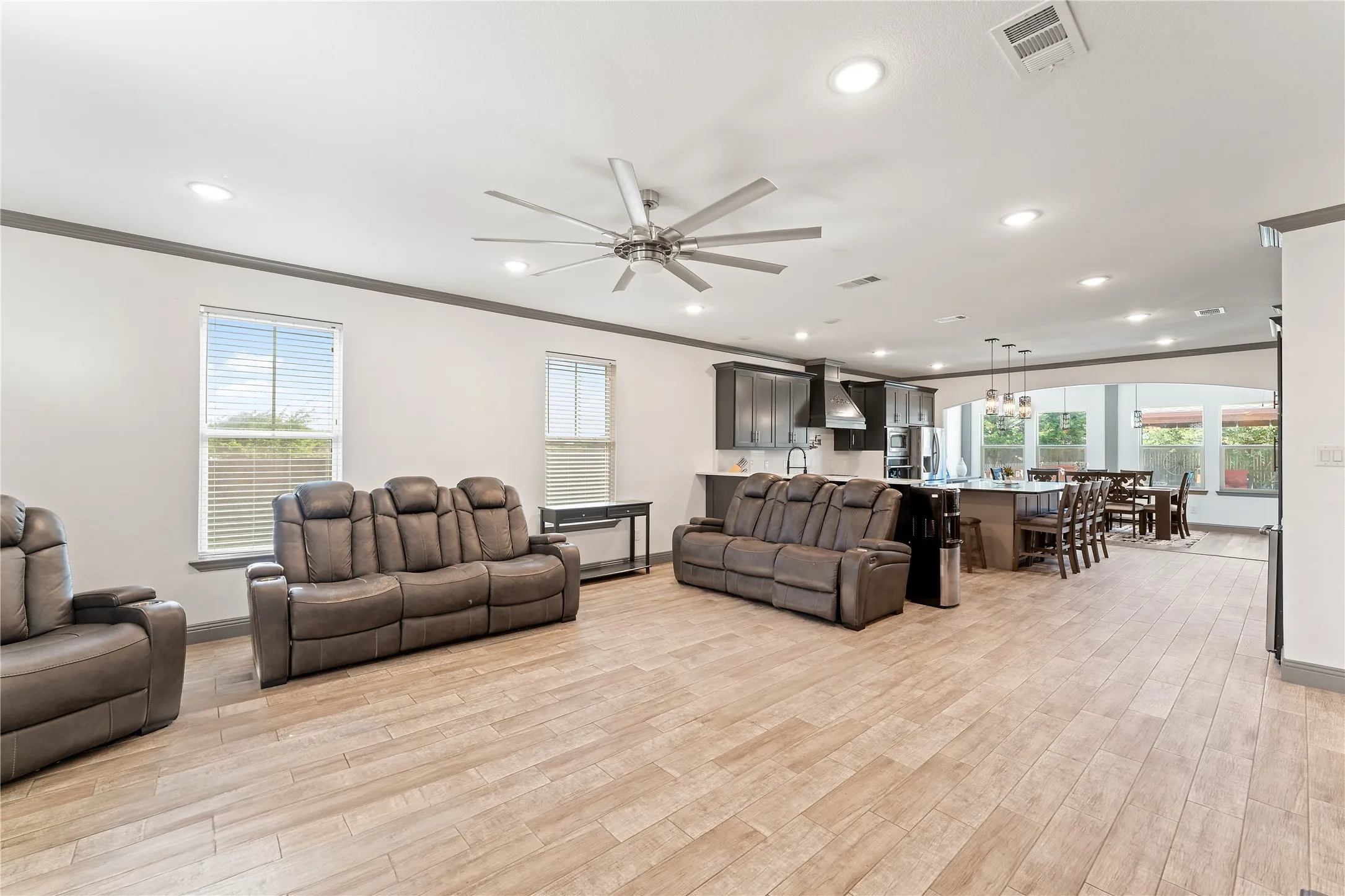 Spacious living area featuring wood-finish flooring, recessed lighting, and a contemporary ceiling fan