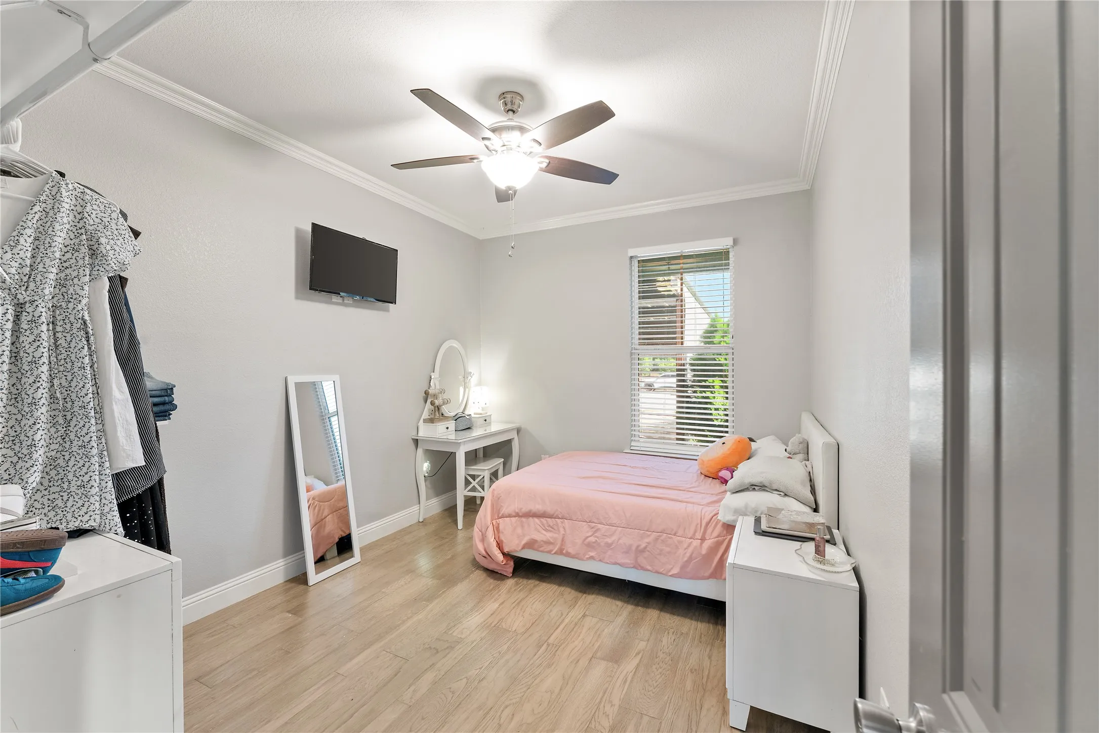 Spacious 3rd room featuring wood-finish flooring, crown molding, and a ceiling fan with integrated lighting